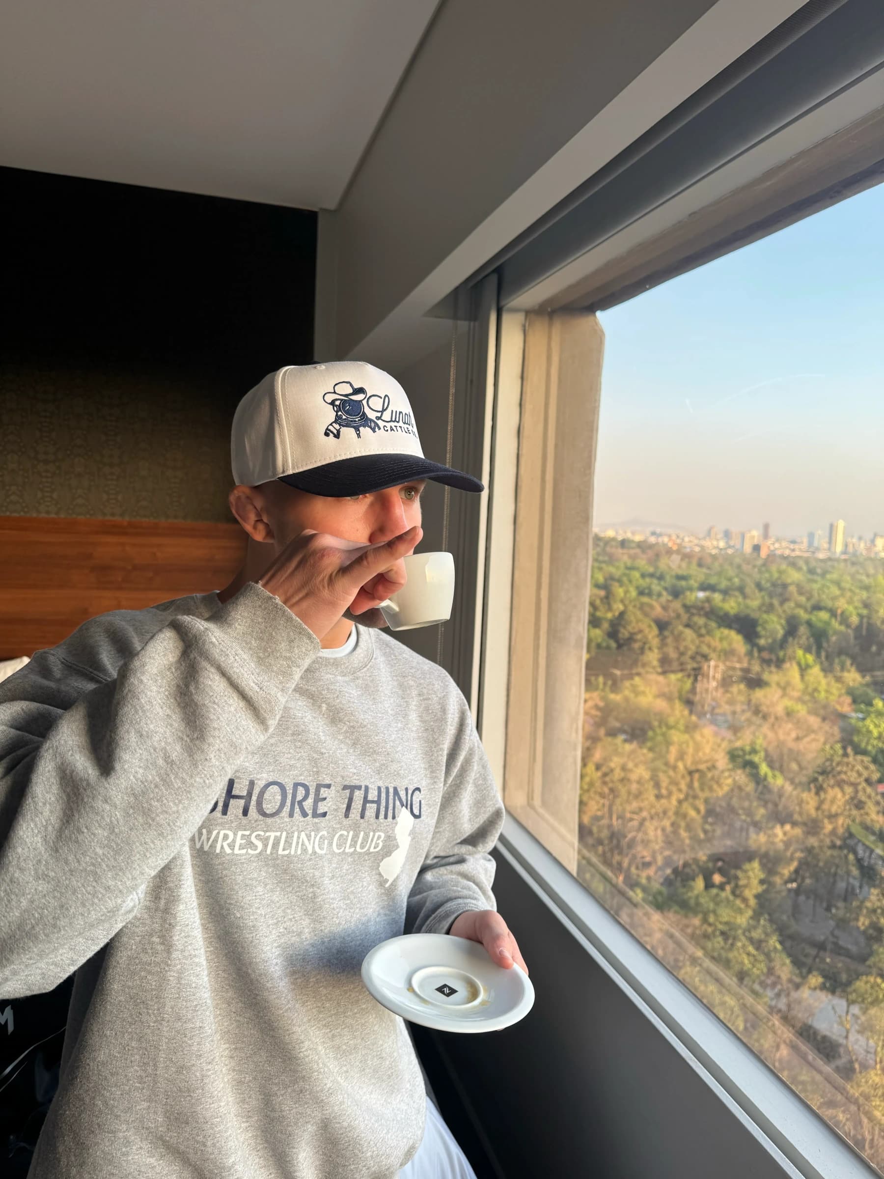 Francis Marshall having coffee beside a window