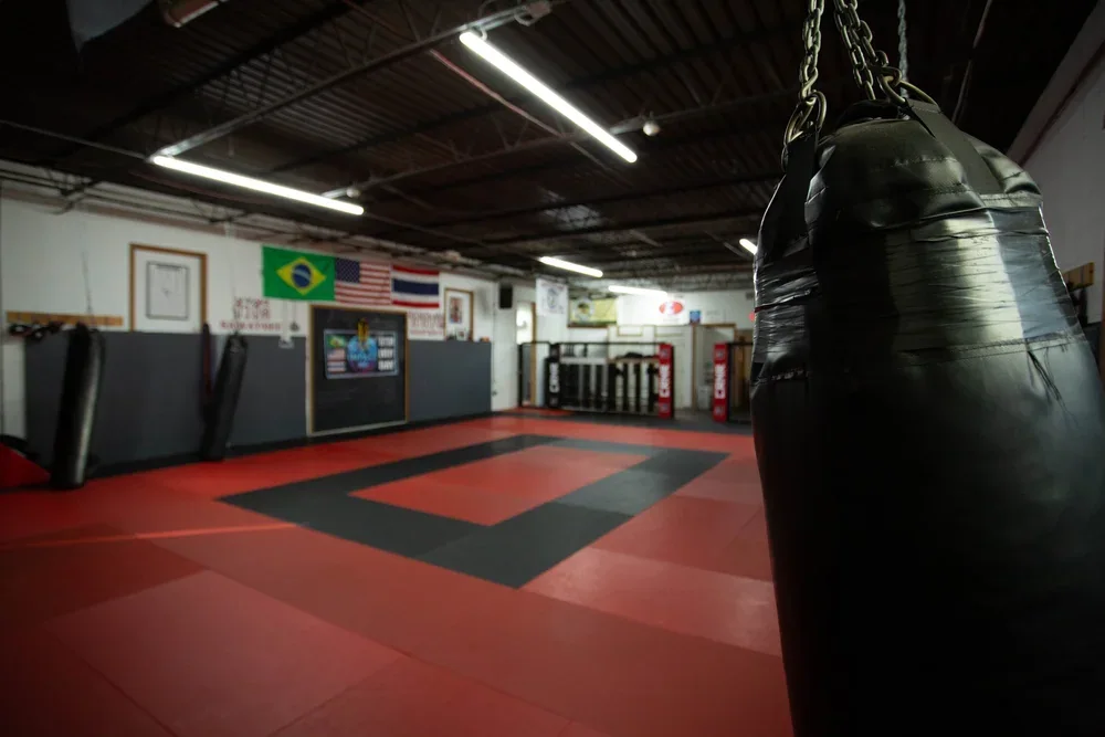 Training floor and heavy bags at Impact Martial Arts and Conditioning